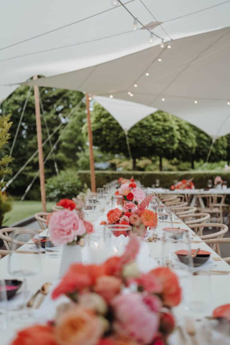Elegantes Dinner-Setup unter einem Stretchzelt bei einer Gartenhochzeit auf einem privaten Estate