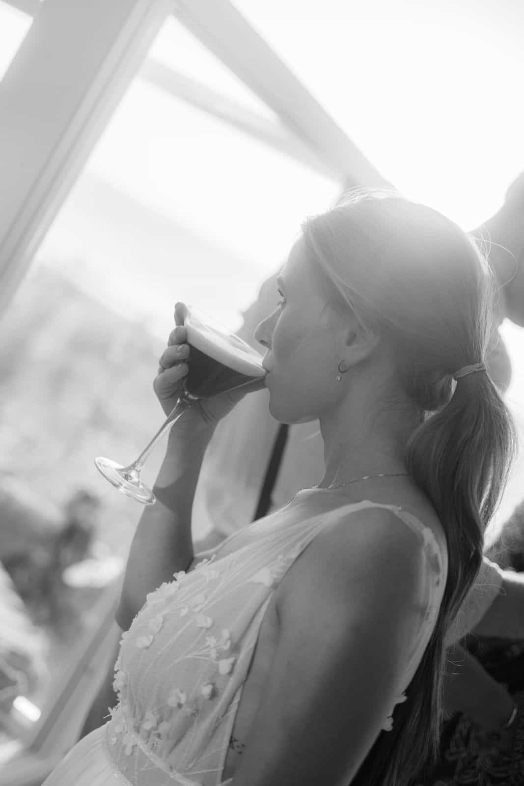 Braut bei einem entspannten Moment mit Espresso Martini während einer Hochzeit – authentische Hochzeitsreportage
