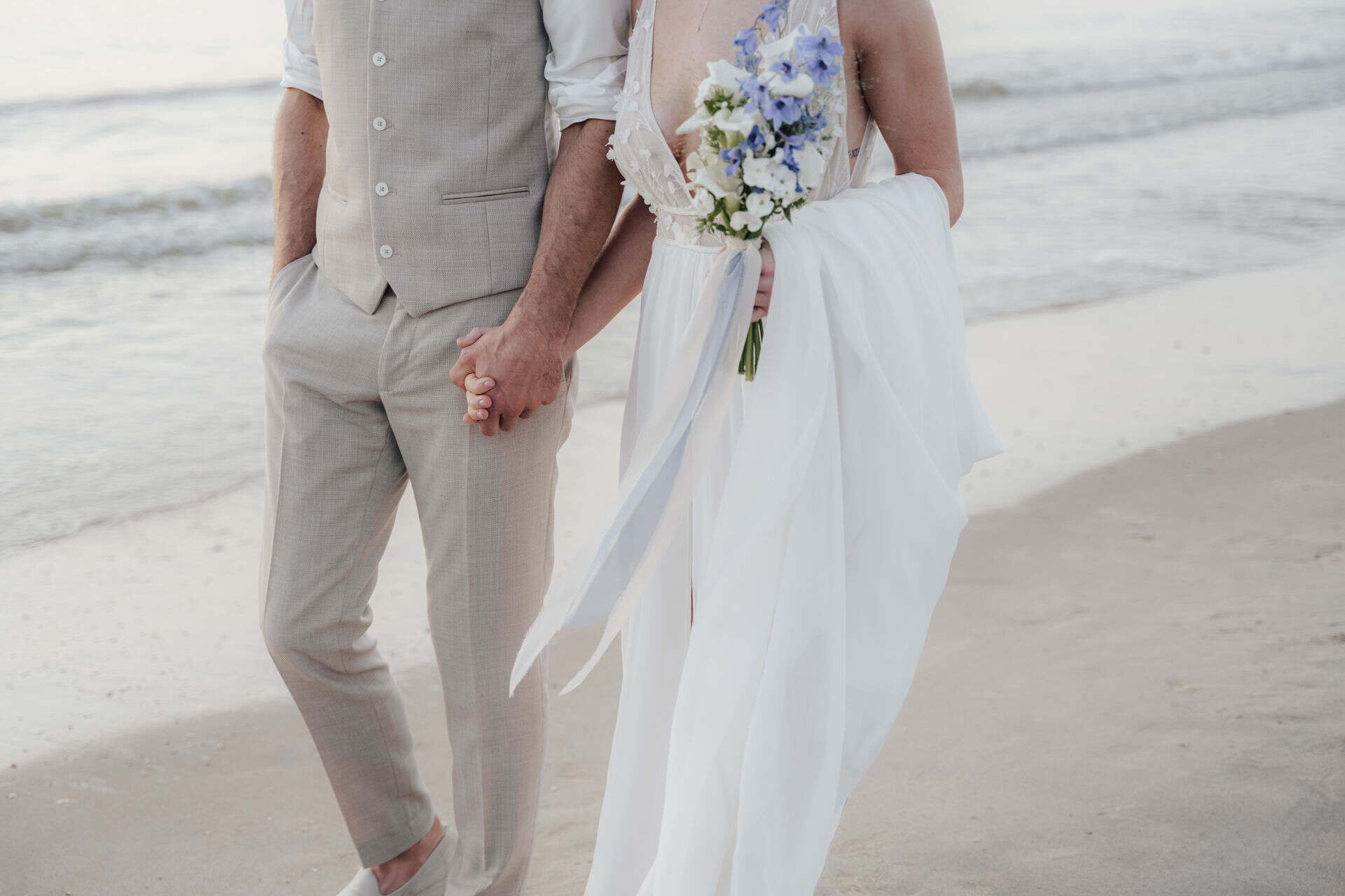 Brautpaar bei einer Hochzeit in Holland Hand in Hand am Meer