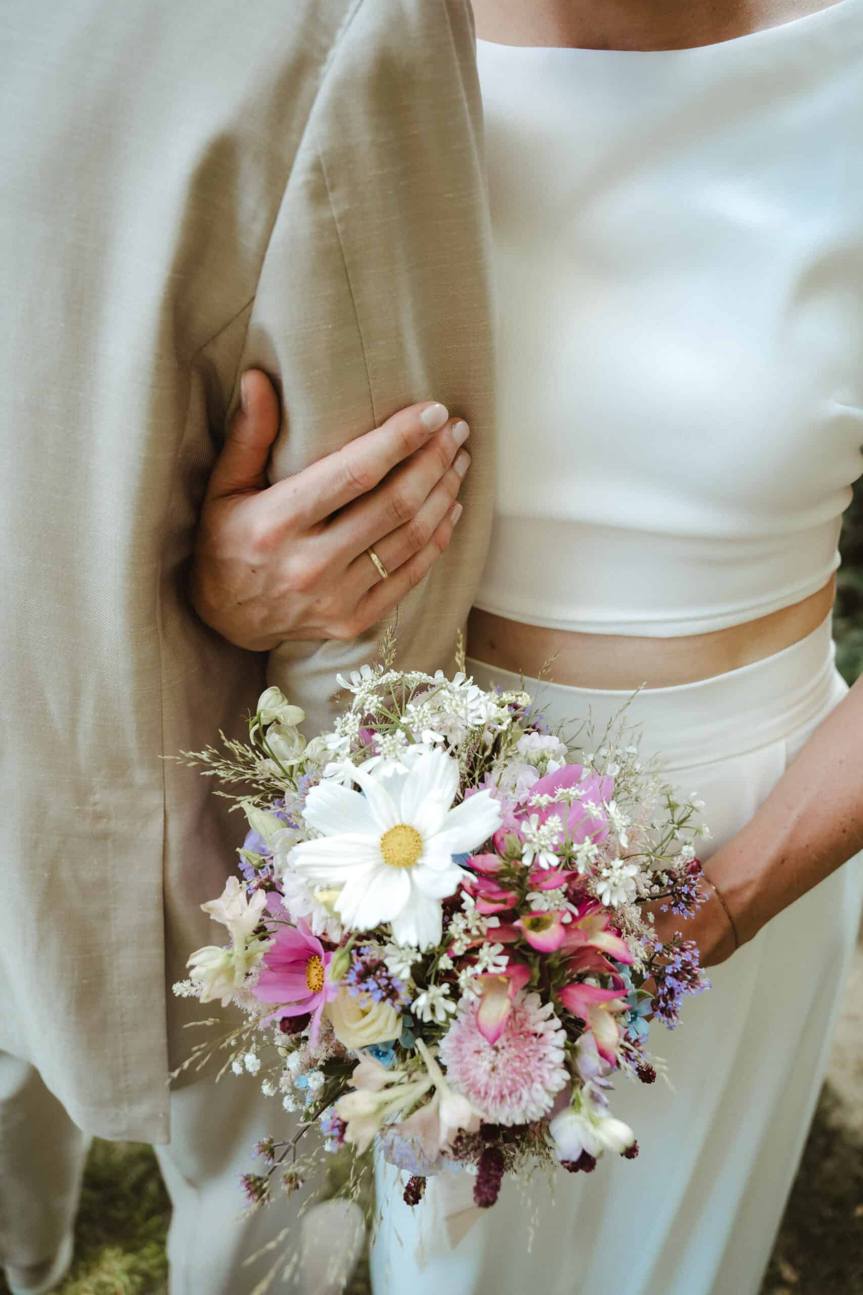Brautpaar mit Blumenstrauß als Teil eines natürlichen Wedding Design Konzepts
