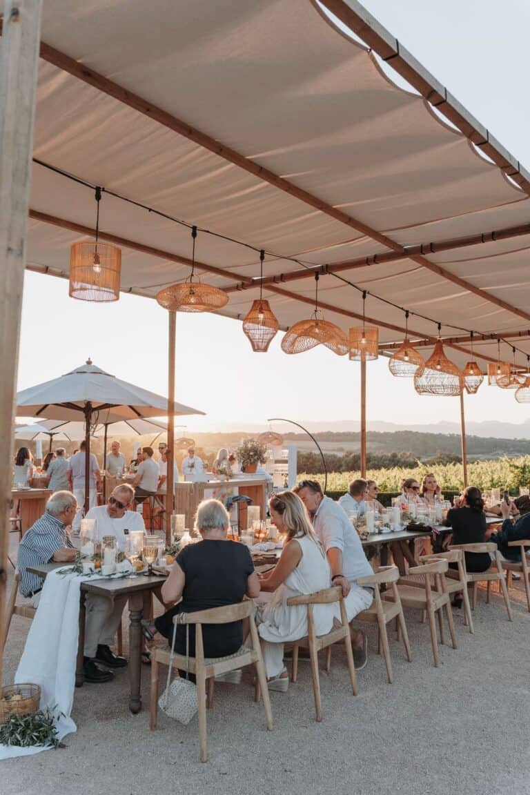 Gemeinsames Dinner beim Wedding Weekend unter freiem Himmel – Outdoor Hochzeit mit langer Tafel und Abendlicht