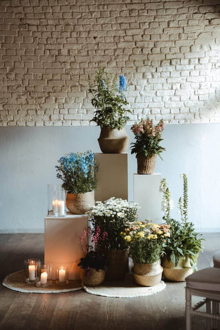 Natürliche Blumeninstallation mit Wiesenblumen, Kerzen und Leinenstoffen als Teil einer modernen Hochzeitsgestaltung