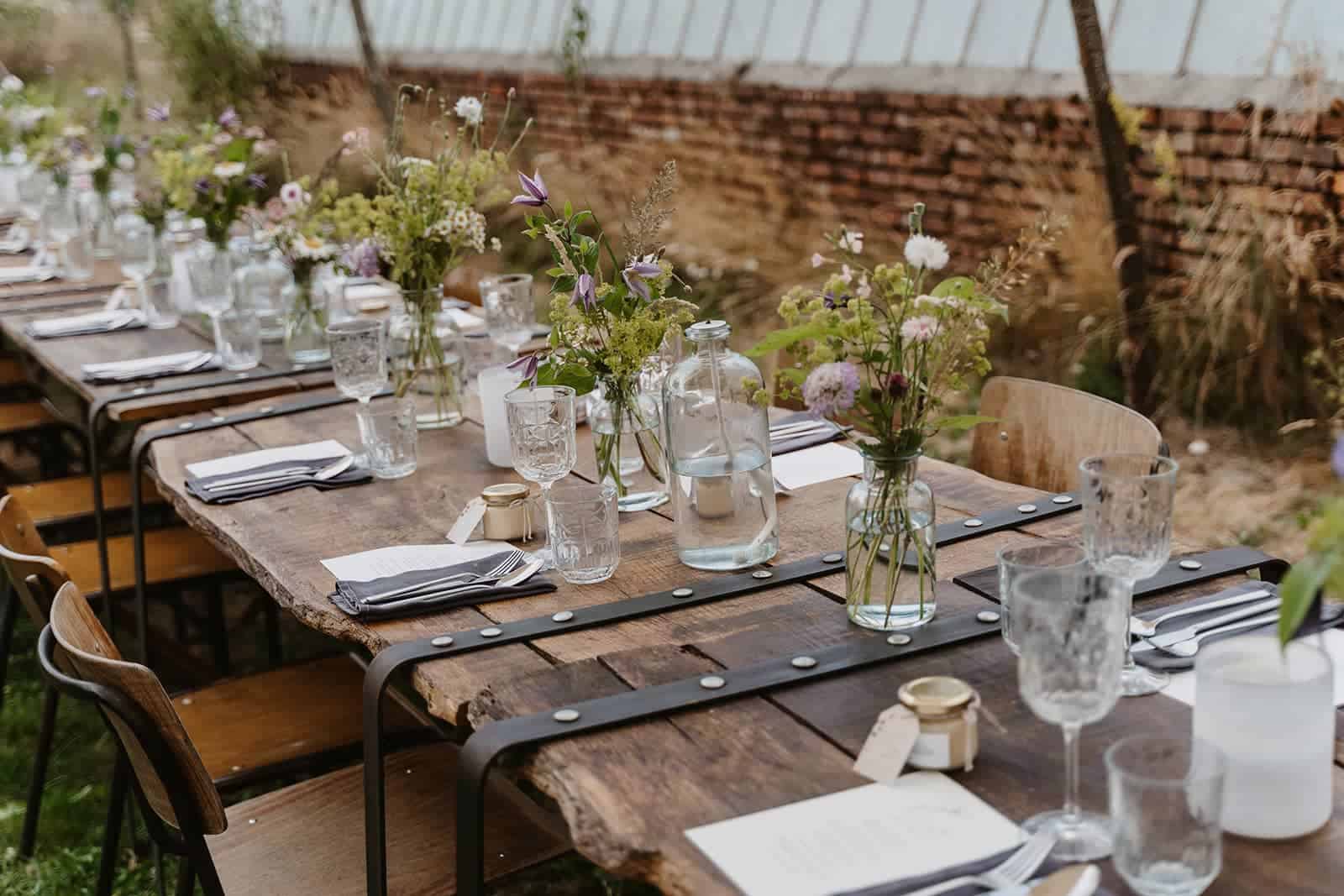 Gedeckte lange Tafel im Freien als Teil einer professionell geplanten Outdoor Hochzeit