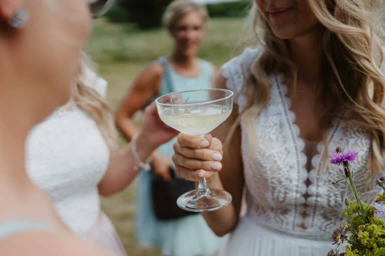 Sektempfang unter freiem Himmel bei einer ungezwungenen Outdoor Hochzeit