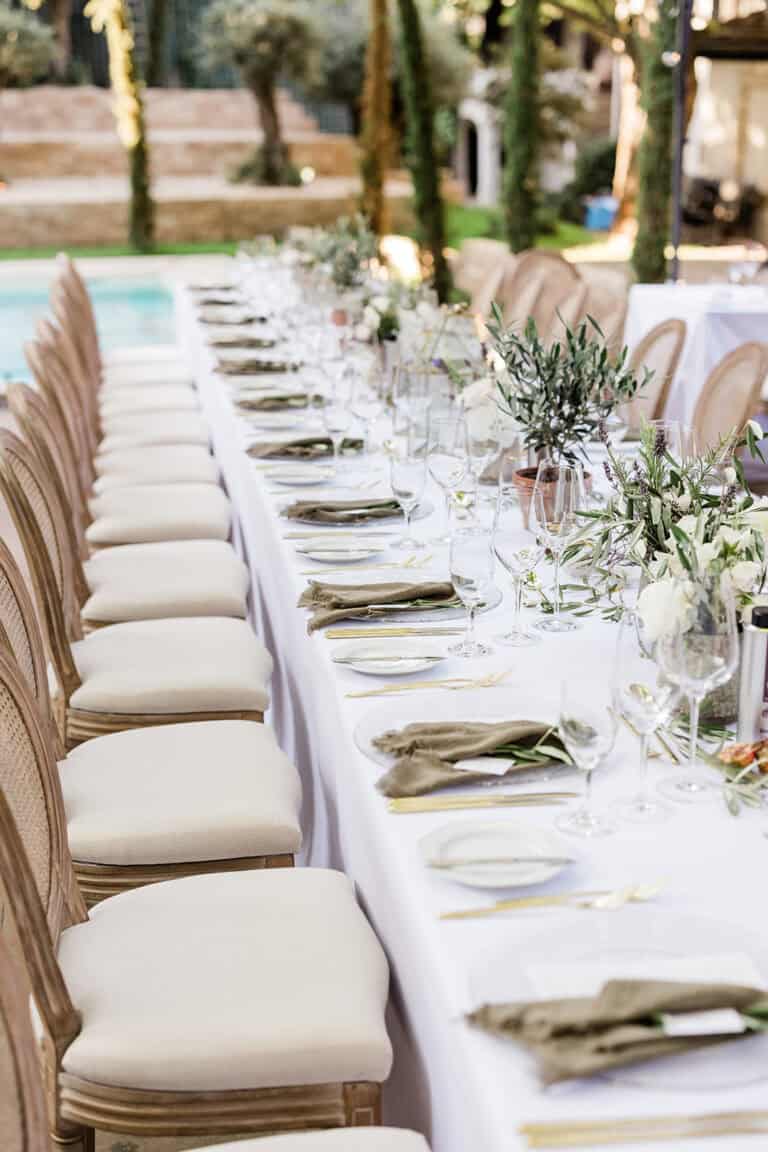 Lange Tafel am Pool als Teil eines sommerlichen Hochzeitswochenendes