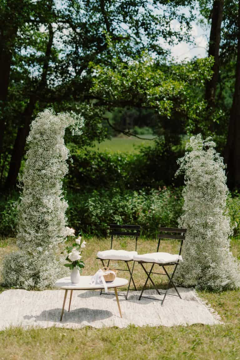 Florale Akzente und ruhige Naturtöne als Teil eines durchdachten Trauungsdesigns für eine Outdoor-Hochzeit.