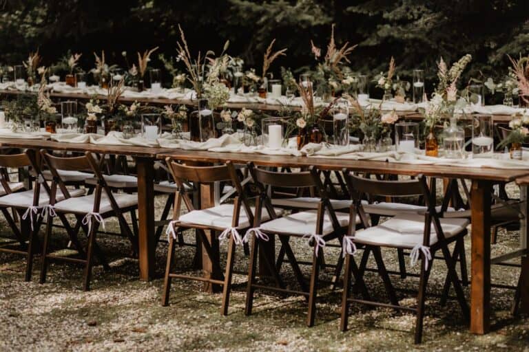 Lange Tafel für eine Outdoor-Hochzeit im Wald, eingebettet in eine natürliche Umgebung.