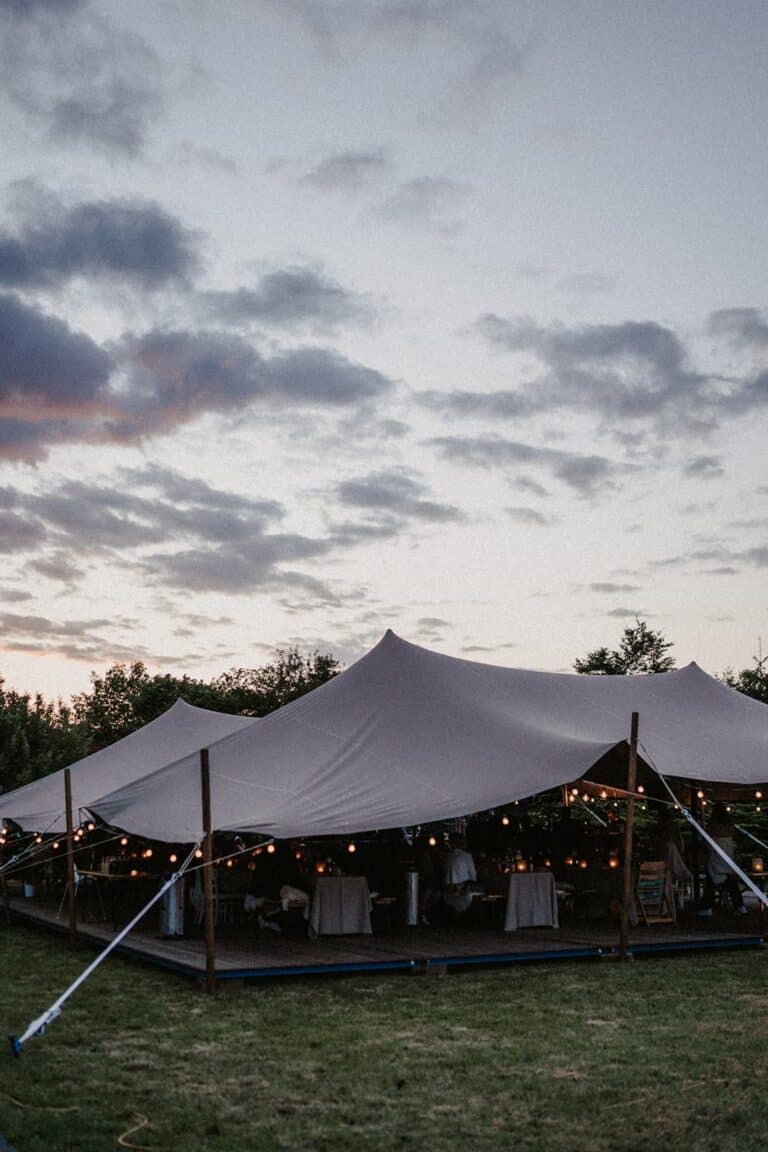 Zelthochzeit im eigenen Garten mit Lichterketten und Abendstimmung, gestaltet für ein privates Wedding Weekend.